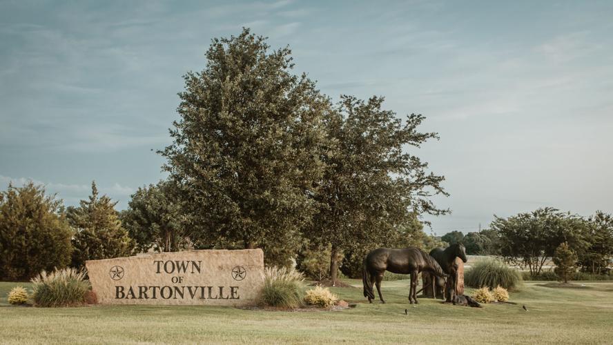 Town of Bartonville stone sign with horse sculptures on a grassy lawn
