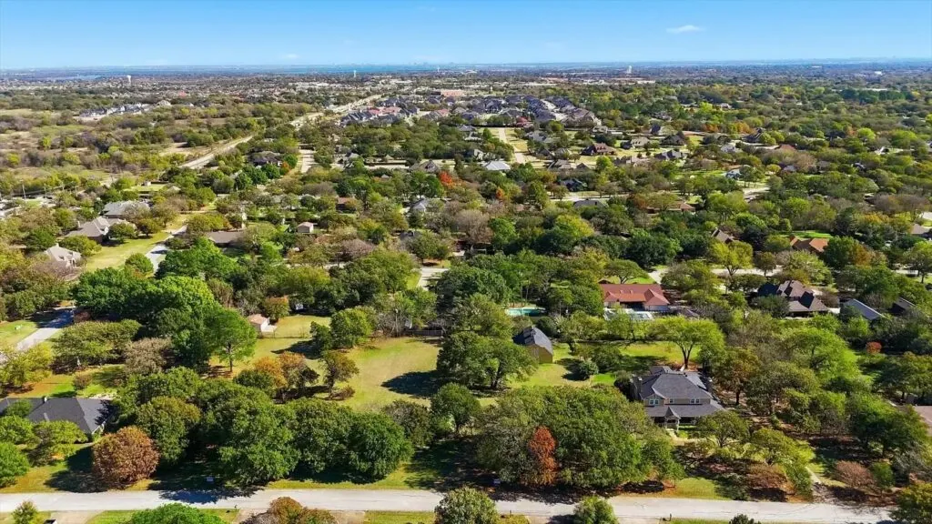 Aerial view of tree-filled neighborhoods with large wooded lots in Double Oak, TX