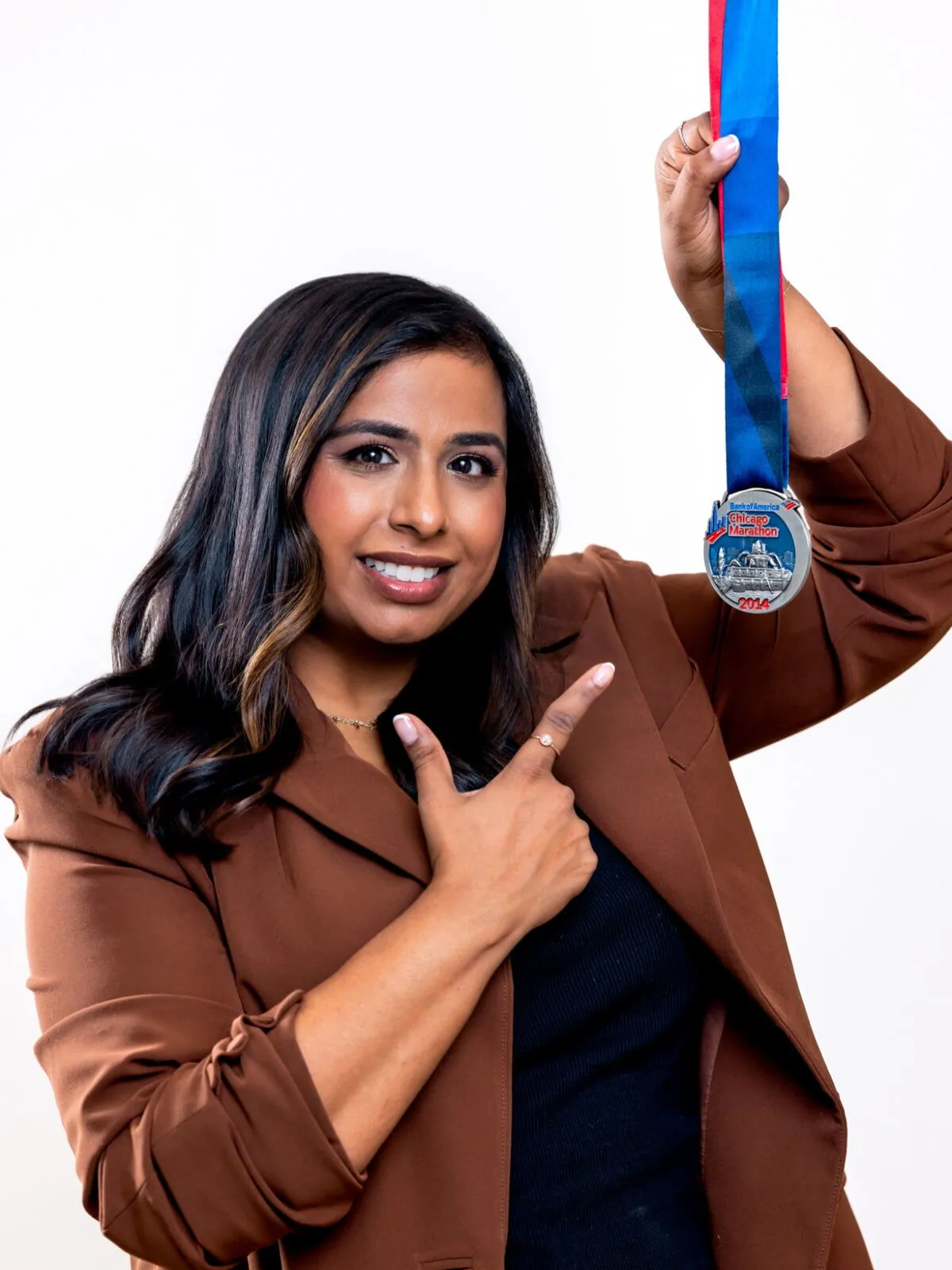 Dr. Anisha Jacob pointing to her 2014 Chicago Marathon medal