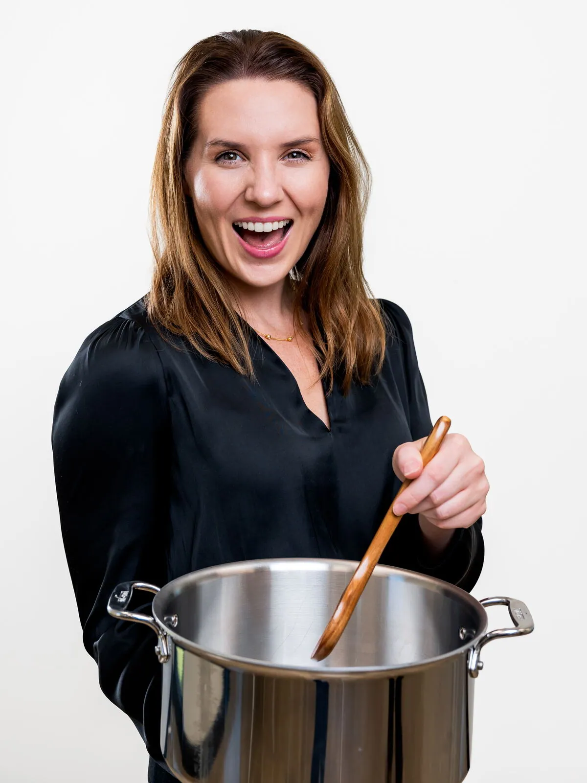 Dr. Ashlin Naquin stirring a stock pot with a wooden spoon