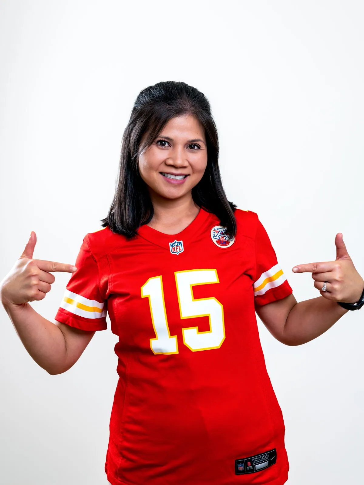 Dr. Michelle Conrad pointing to her Kansas City Chiefs number 15 jersey