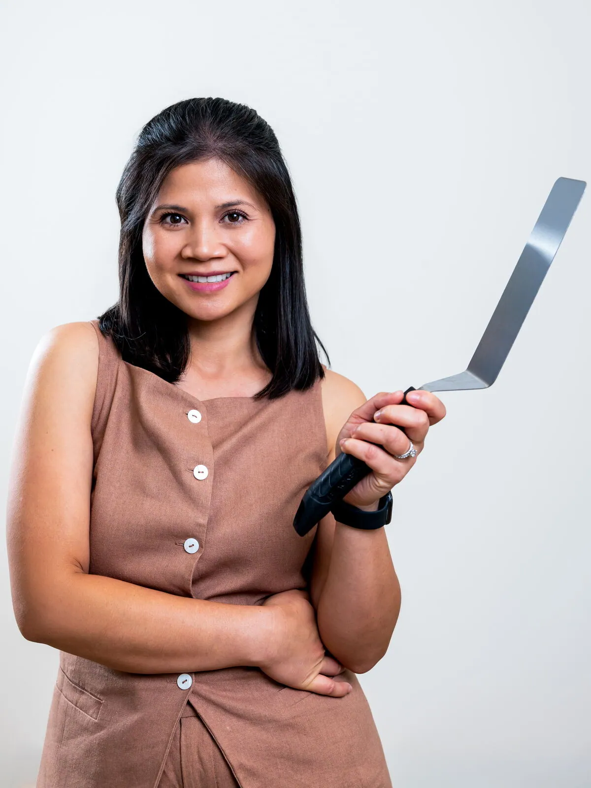 Dr. Michelle Conrad smiling as she holds up a spatula
