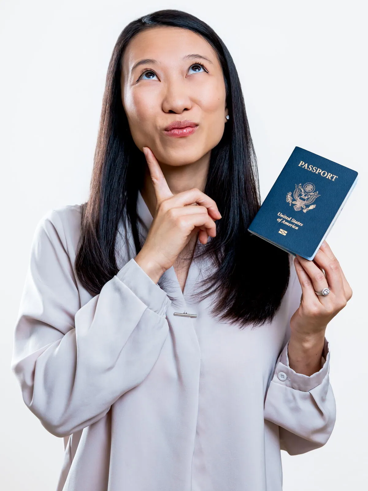 Dr. Yee Choi holding a U.S. passport and daydreaming about her next trip