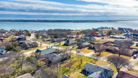 Aerial view of homes along the lakeshore in Lakewood Village, TX