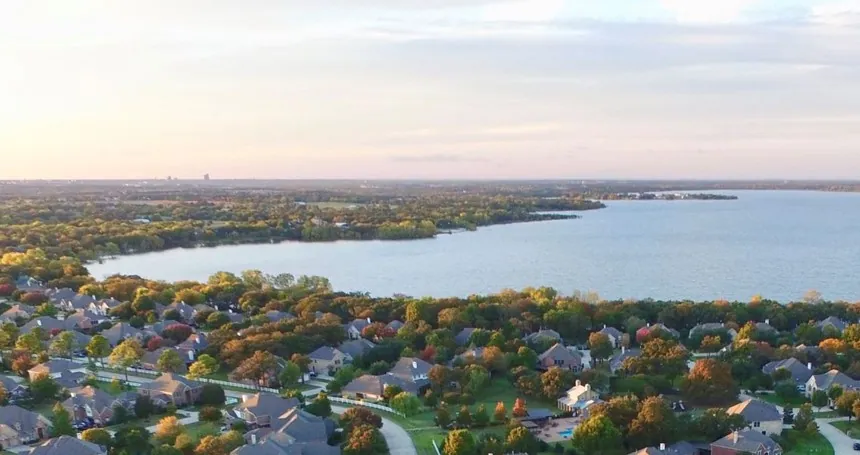 Aerial view of tree-lined neighborhoods along the lake near Shady Shores, TX, in autumn