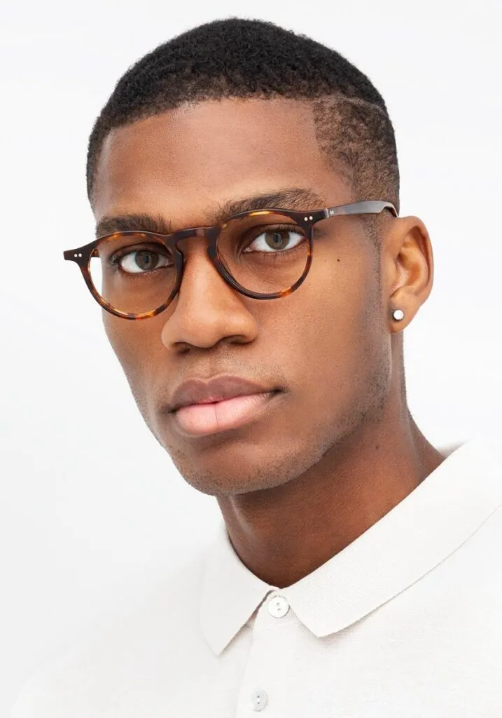 Young man wearing round tortoiseshell KREWE frames