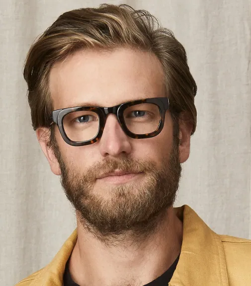 Bearded man wearing thick black MOSCOT frames