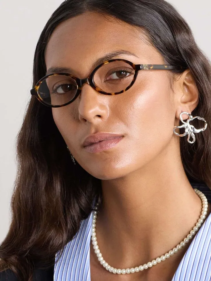 Woman wearing oval tortoiseshell Miu Miu frames