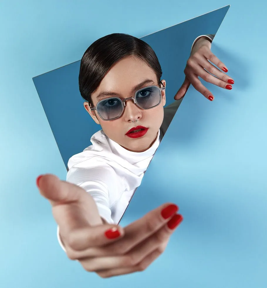 Woman wearing blue-tinted Movitra sunglasses against a blue backdrop