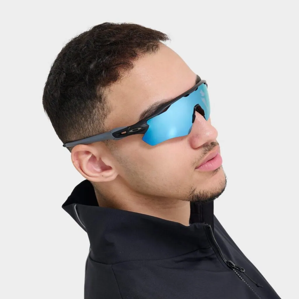 Young man wearing Oakley sport sunglasses with blue mirrored lenses