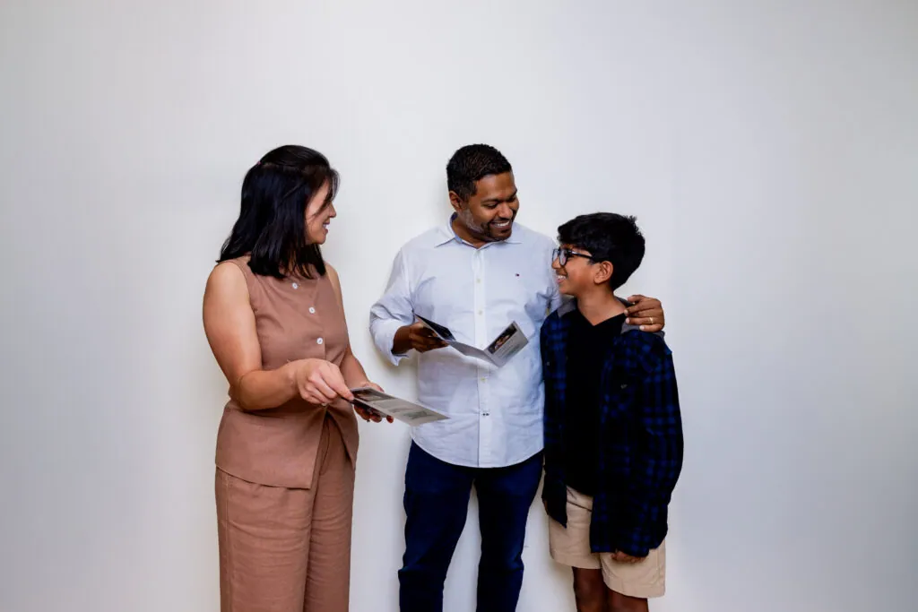 A Village Vision Center optometrist shows a father and son a Stellest lens brochure