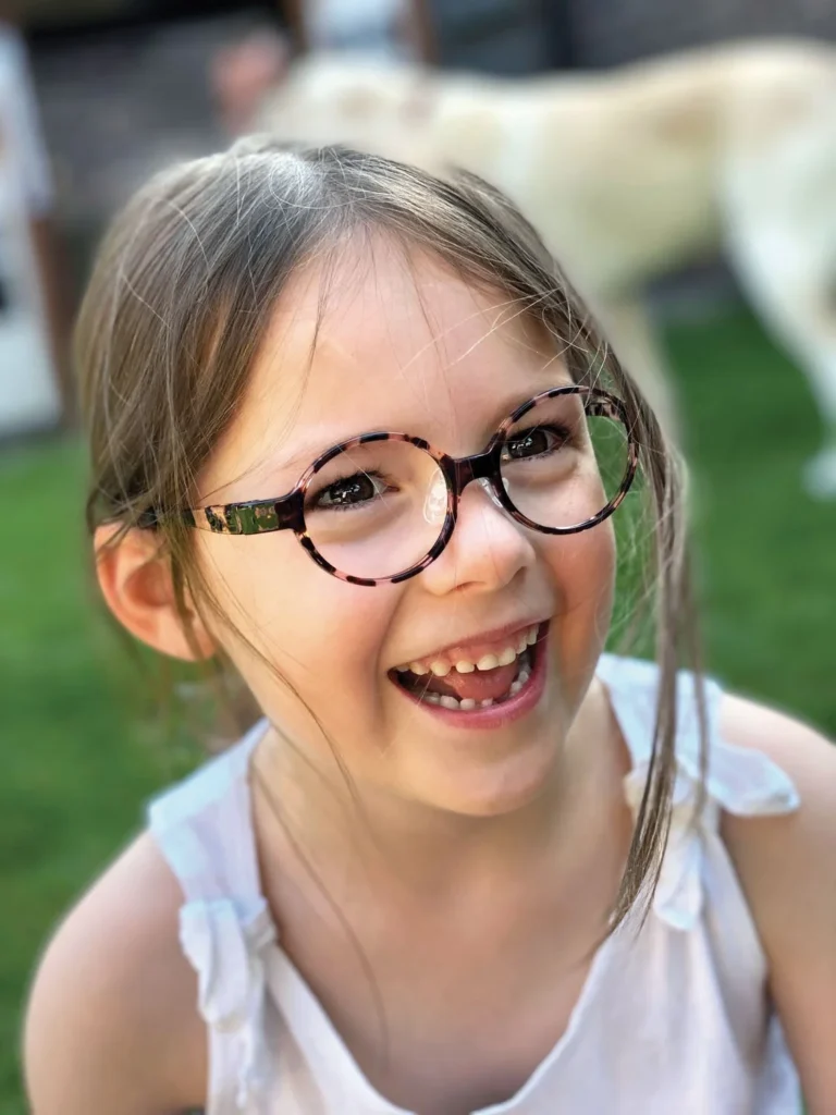 Laughing girl wearing round tortoiseshell Tomato Glasses frames