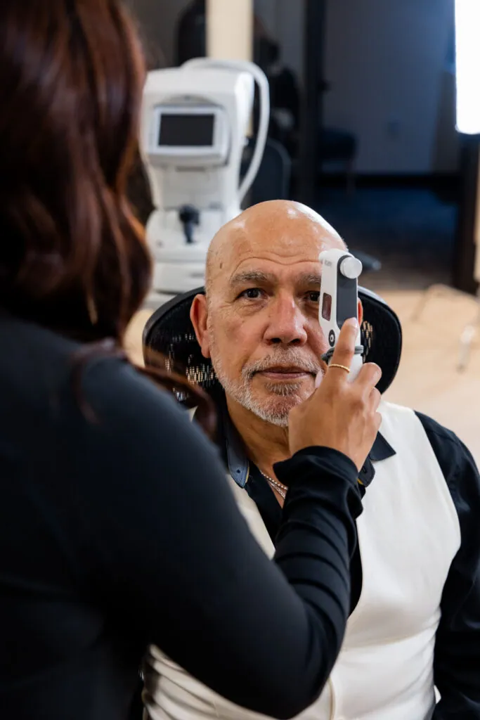 A Village Vision Center optometrist checks a patient’s eye pressure with a handheld tonometer