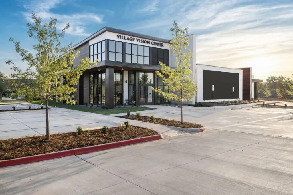 The Village Vision Center building at 113 Barnett Blvd, with its name above the glass entrance