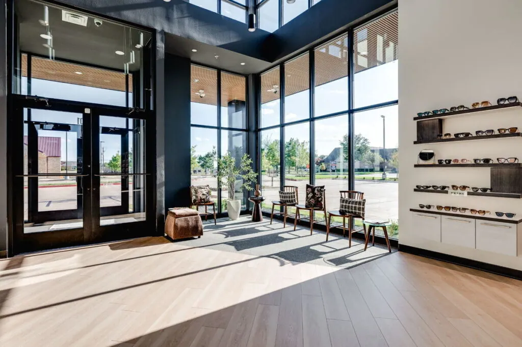 The glass entrance and window seating at Village Vision Center, beside a wall of designer sunglasses